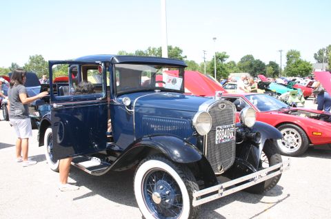1968 Shelby GT500 - A vintage pickup truck is displayed at an outdoor car show, with other vehicles visible in the background.