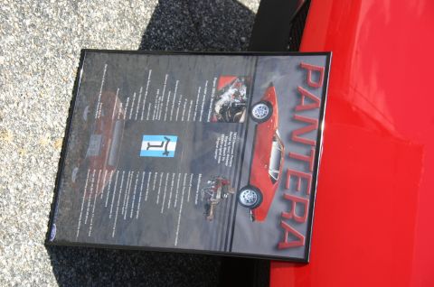 1968 Shelby GT500 - Document detailing a 1973 De Tomaso Pantera is displayed on a red vehicle.
