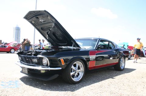1968 Shelby GT500 - A black 1969 Ford Mustang Boss 427 with red racing stripes is displayed with its hood open at a car show.