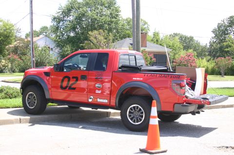 1968 Shelby GT500 - This red Ford F-150 SVT Raptor pickup truck is parked on a street with its tailgate down.
