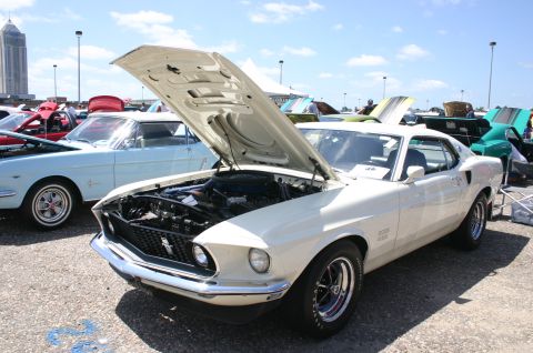 1968 Shelby GT500 - White 1969 Ford Mustang Boss 429 on display with hood open at a car show.