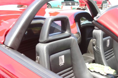 1968 Shelby GT500 - Interior view of a red convertible, with a teal Mustang visible behind it.