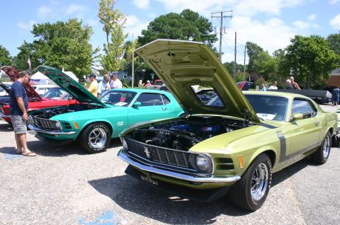 1968 Shelby GT500 - Two Ford Mustangs, a green Boss 302 and a teal model, displayed with hoods open at an outdoor car show.