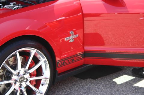 1968 Shelby GT500 - Side view of a red Ford Mustang Shelby GT500, showing its distinctive badging and racing stripes.