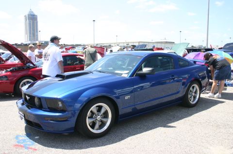 1968 Shelby GT500 - A blue Ford Mustang GT is displayed at a car show with other vehicles.