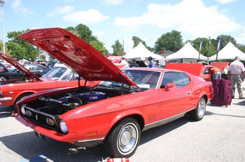 1968 Shelby GT500 - A red 1971 Ford Mustang Mach 1 is displayed with its hood open at a car show, alongside other vehicles.