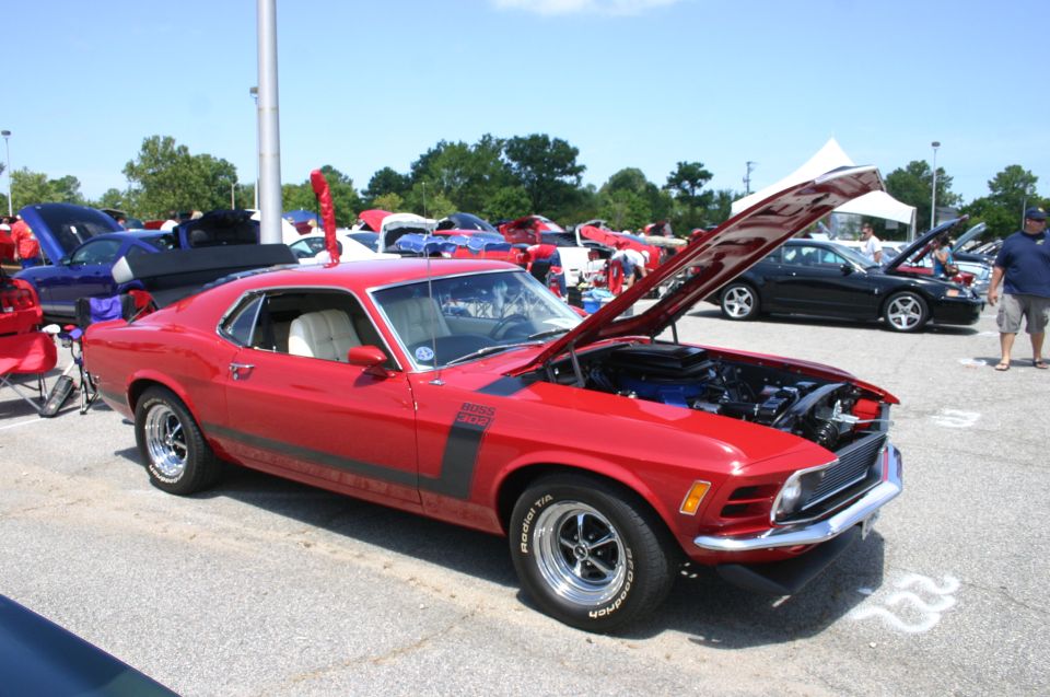 Red 1970 Ford Mustang Boss 302 with black stripes and hood scoop, front passenger side view, hood open