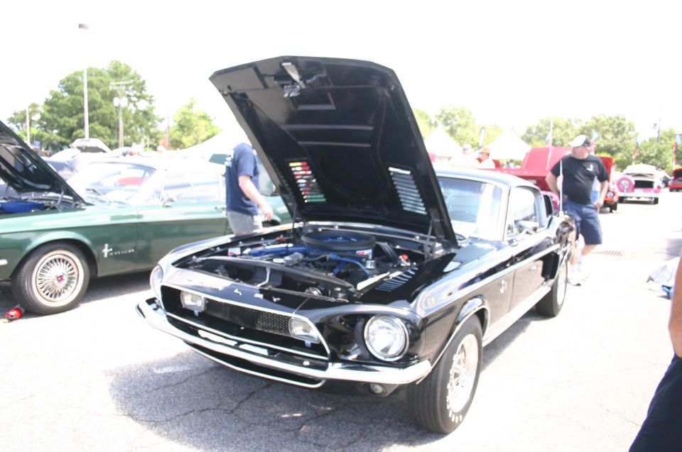 Black 1968 Shelby GT500 with hood open, showing engine