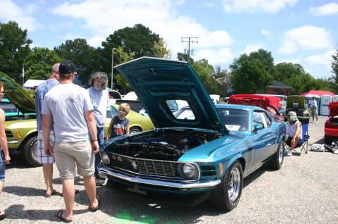 1968 Shelby GT500 - Teal 1970 Ford Mustang Mach 1 on display with its hood open, surrounded by onlookers.