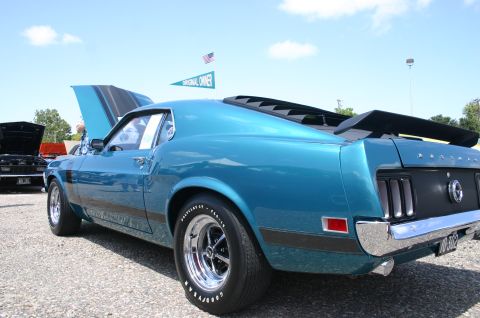 1968 Shelby GT500 - A blue 1969 Ford Mustang Mach 1 is parked at an outdoor car show with its hood open.