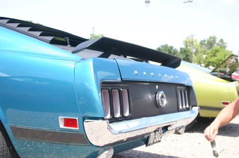 1968 Shelby GT500 - Rear view of a blue muscle car a spoiler and louvers, with another car visible in the background.