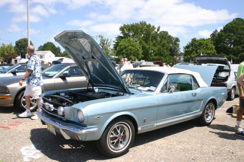 1968 Shelby GT500 - A light blue 1965 Ford Mustang convertible is displayed with its hood open at a car show.
