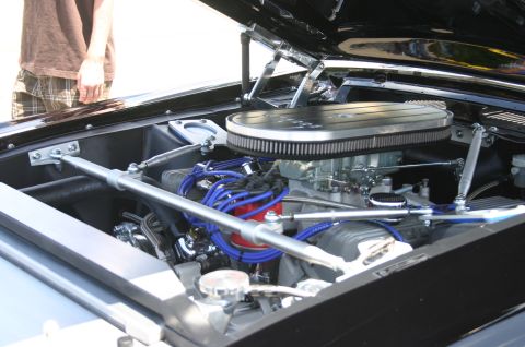 1968 Shelby GT500 - The engine bay of a 1968 Shelby GT500 features a V8 engine with a prominent chrome air cleaner and vibrant blue spark plug wires.