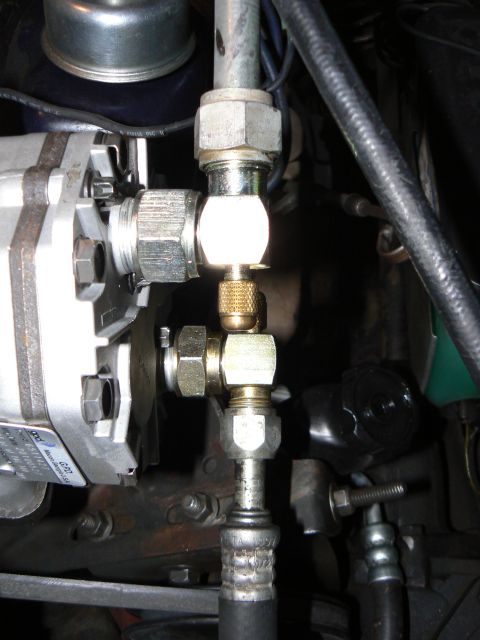 1978 Ford Bronco - This photo shows a close-up view of automotive air conditioning lines and a service port with brass fittings.