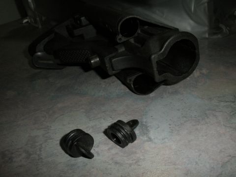 1996 Ford Bronco - A black plastic automotive part and two caps are shown on a textured surface.