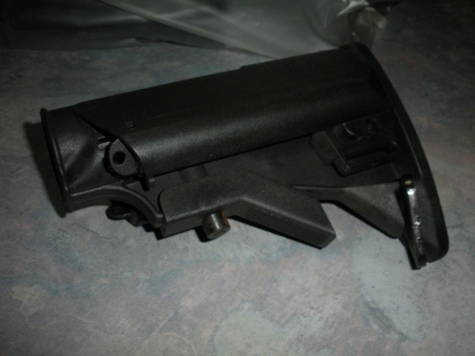 Black rifle stock on a textured surface