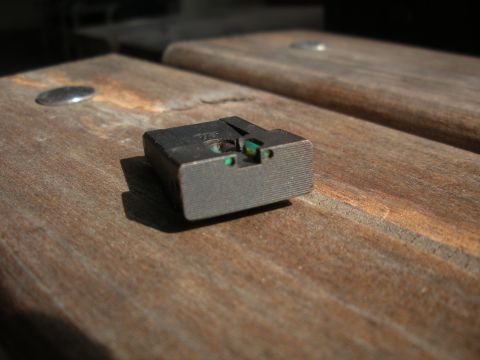 1996 Ford Bronco - A gun sight with green dots is shown resting on a wooden surface.