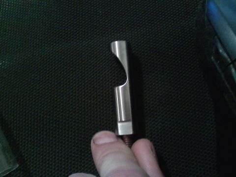1990 Ford Bronco - A close-up shows a custom metal part with a unique cutout, held by a person's fingers.