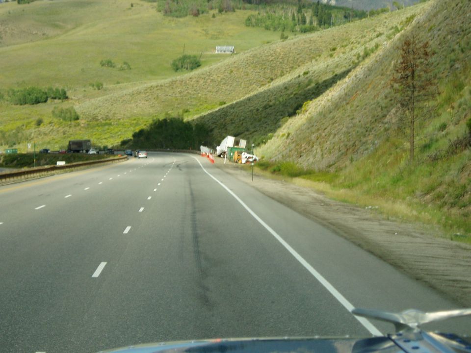 Tractor-trailer accident on highway shoulder with debris and cones
