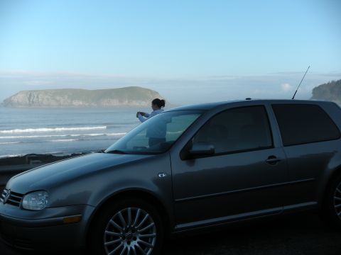 1991 Ford Bronco - Volkswagen Golf Mk4 parked near the coast on a foggy day.