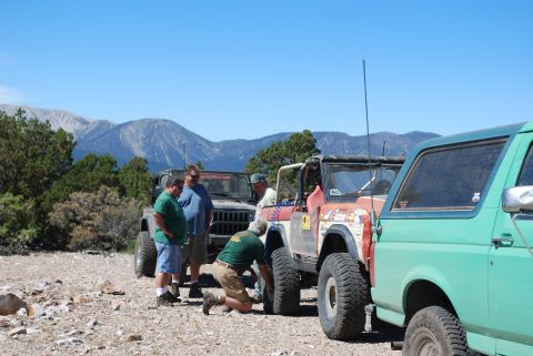 1996 Ford Bronco - People gathered around off-road vehicles in a mountainous, outdoor setting.