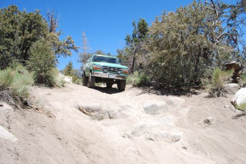 1996 Ford Bronco - This 1996 Ford Bronco navigates a challenging rocky path under a clear blue sky.