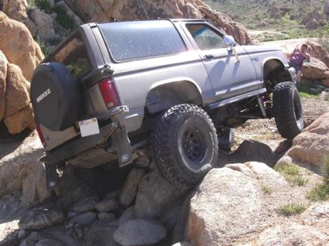 1990 Ford Bronco II - Ford Bronco II navigating a rocky trail, showing off its off-road capabilities.