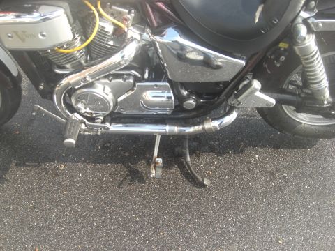 1986 Honda Shadow Aero - Motorcycle engine and exhaust detail shot on a wet asphalt surface.