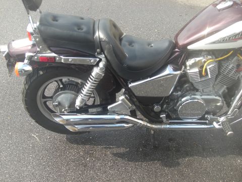 1986 Honda Shadow Aero - This maroon motorcycle features dual exhaust pipes and black seats, with a visible Honda logo on the engine casing.