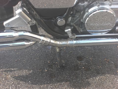 1986 Honda Shadow Aero - Motorcycle engine detail showing the HONDA logo on the side cover and chrome exhaust pipes.