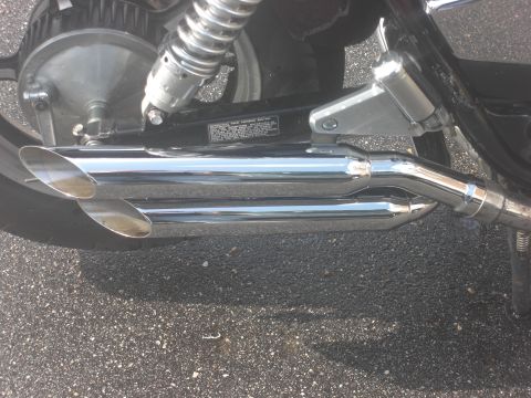 1986 Honda Shadow Aero - Detail shot of a motorcycle's chrome exhaust system and rear suspension components.