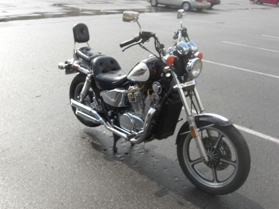 Burgundy Honda Shadow cruiser motorcycle, 3/4 front view on wet pavement