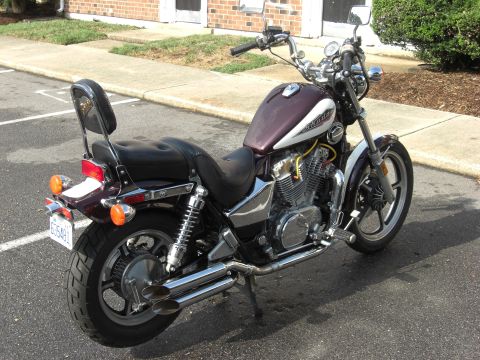 1986 Honda Shadow Aero - A parked Honda motorcycle with a passenger backrest and dual exhaust pipes.