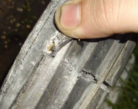 1979 Ford Bronco - A finger is shown pressing down on a damaged rubber seal, revealing wear and tear.