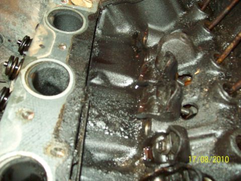 1985 Ford Bronco - Engine block interior with valve train components visible, coated in oil.