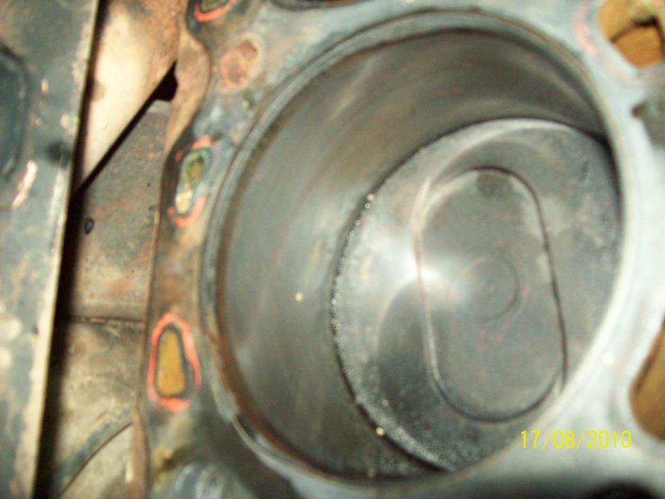 Close-up of an engine cylinder with visible wear marks. Watermark reads 'SUPERMOTORS'