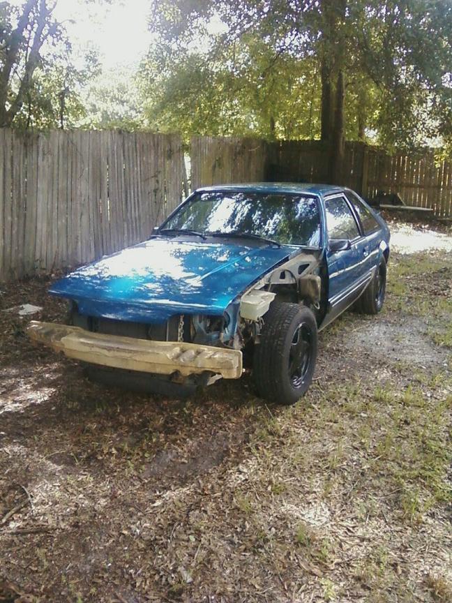 1989 Ford Mustang coupe, blue, missing front bumper and headlights