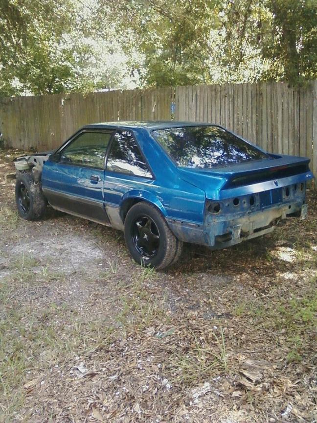 blue 1989 Ford Mustang coupe, missing front end parts, parked outside