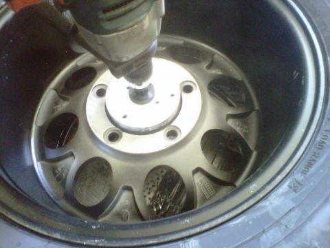 1994 Ford F-150 - A drill is used on a vehicle's wheel, with a Supermotors.net logo in the corner.