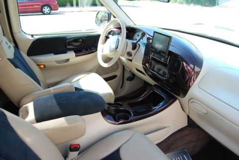 2007 Ford Mustang - The interior of a truck features two-tone seats, wood grain accents, and an aftermarket entertainment system.