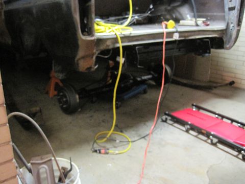1979 Ford Bronco - The rear suspension of a 1978 Ford Bronco is visible, supported by jack stands in a workshop setting.