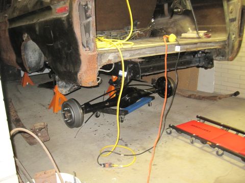 1979 Ford Bronco - Rear axle assembly is being worked on while the vehicle is supported by jack stands.