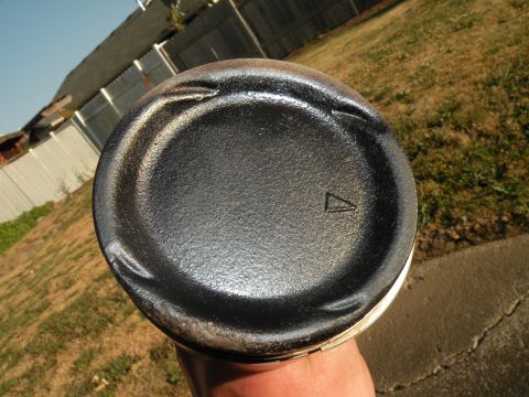 1998 Subaru Legacy - Close-up of an engine piston, showing its top surface with minor wear and a triangular marking.