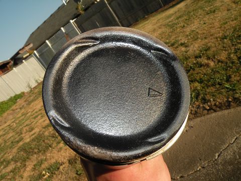 1998 Subaru Legacy - Close-up of a piston, likely from an engine, with visible wear marks and a triangular indicator.
