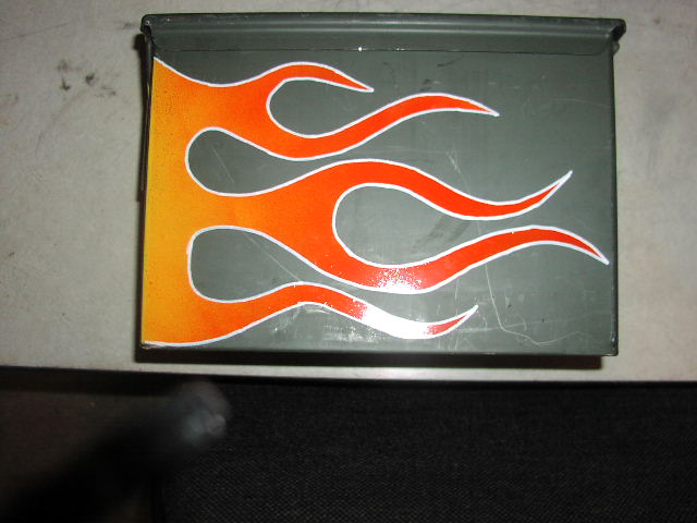 Gray primered panel painted with orange and yellow hot rod flames outlined in white