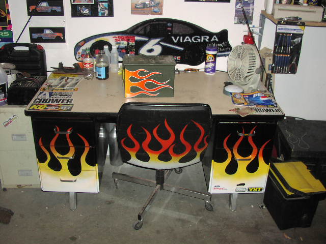 Garage desk and chair painted with orange flames under a Viagra No. 6 race car wall sign