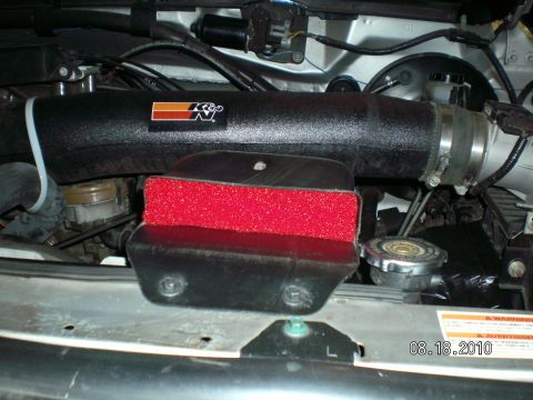 1996 Ford Bronco - Close-up view of a K&N air intake system installed in a vehicle's engine bay.