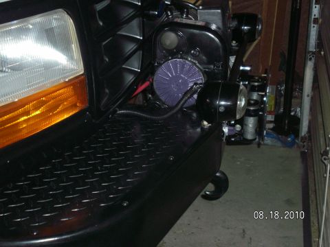 1996 Ford Bronco - Close-up of a vehicle's front end, aftermarket lighting and visible engine parts.
