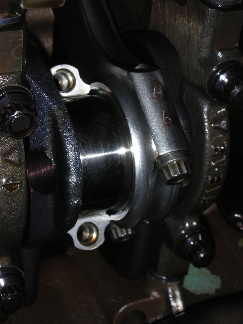 Close-up of engine connecting rod with stamped numbers