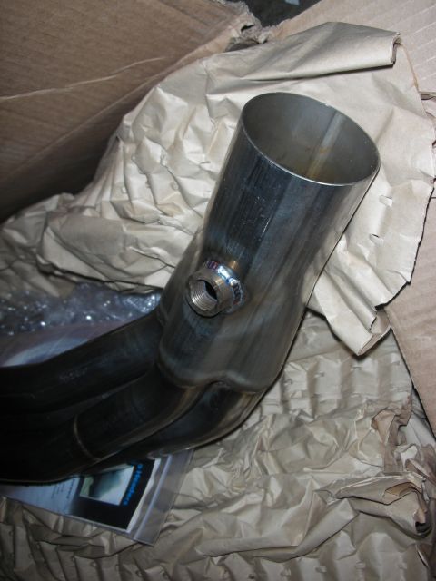 1992 Ford Crown Victoria - A close-up view of an exhaust manifold, partially obscured by packing material within a cardboard box.
